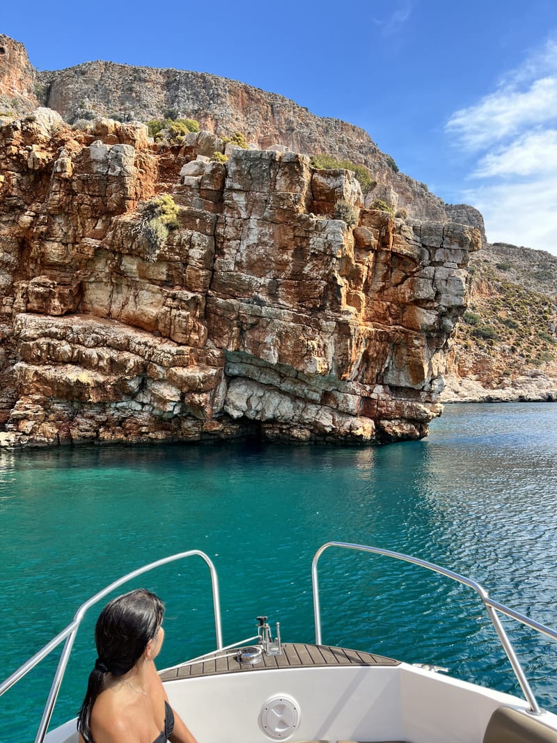 A guest standing at the edge of the cliff above Návlakas inlet